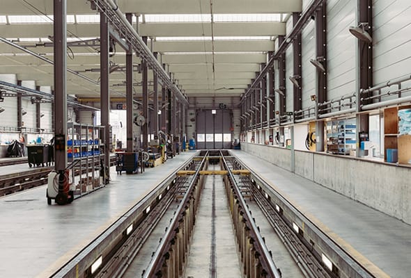 Interior view of an industrial manufacturing facility with an extensive track system for material handling.