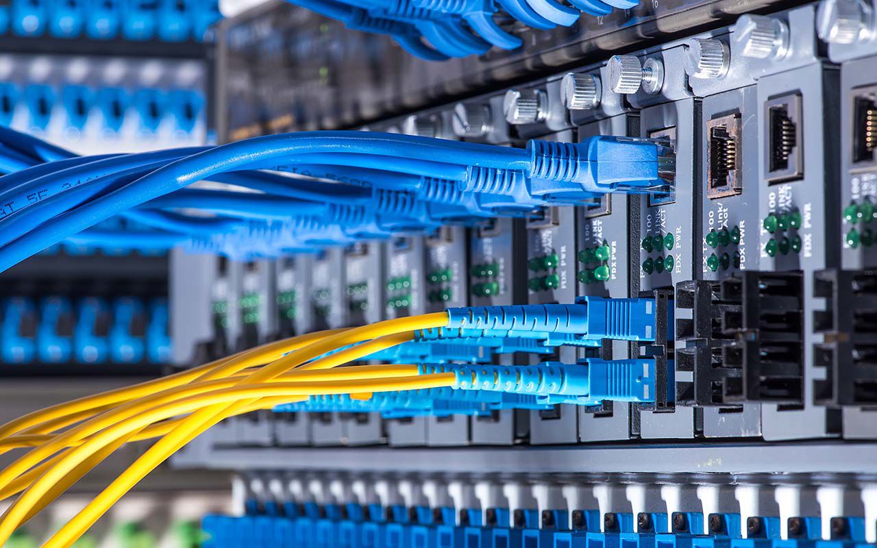 a switch with fiber optical and network cables connected.